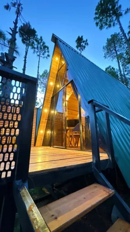 Cozy wooden hut with a geyser and a bed.